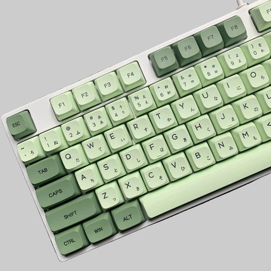 Keyboard with green keys on a gray surface